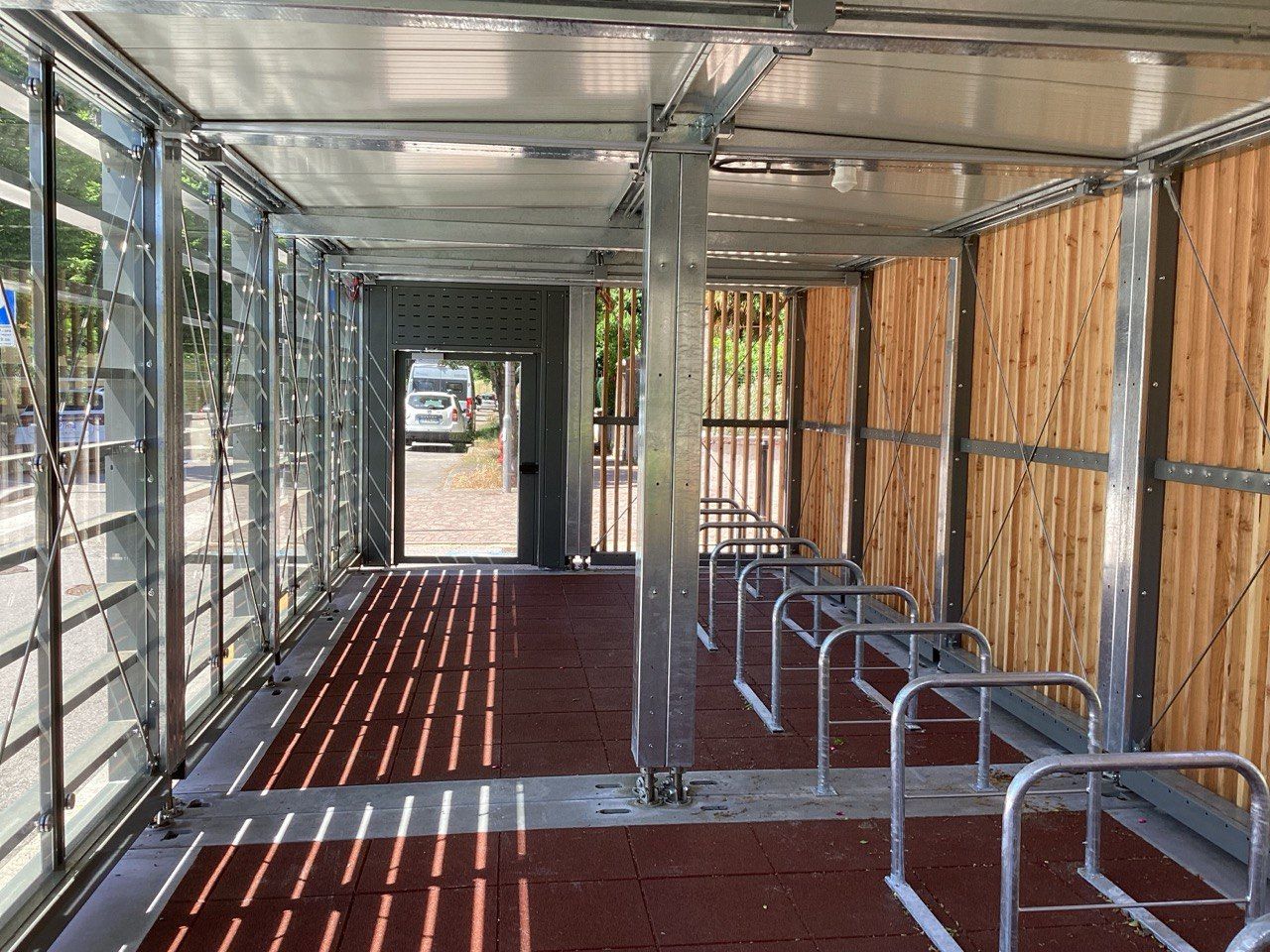 Passaggio coperto con rastrelliere per biciclette e lamelle in legno