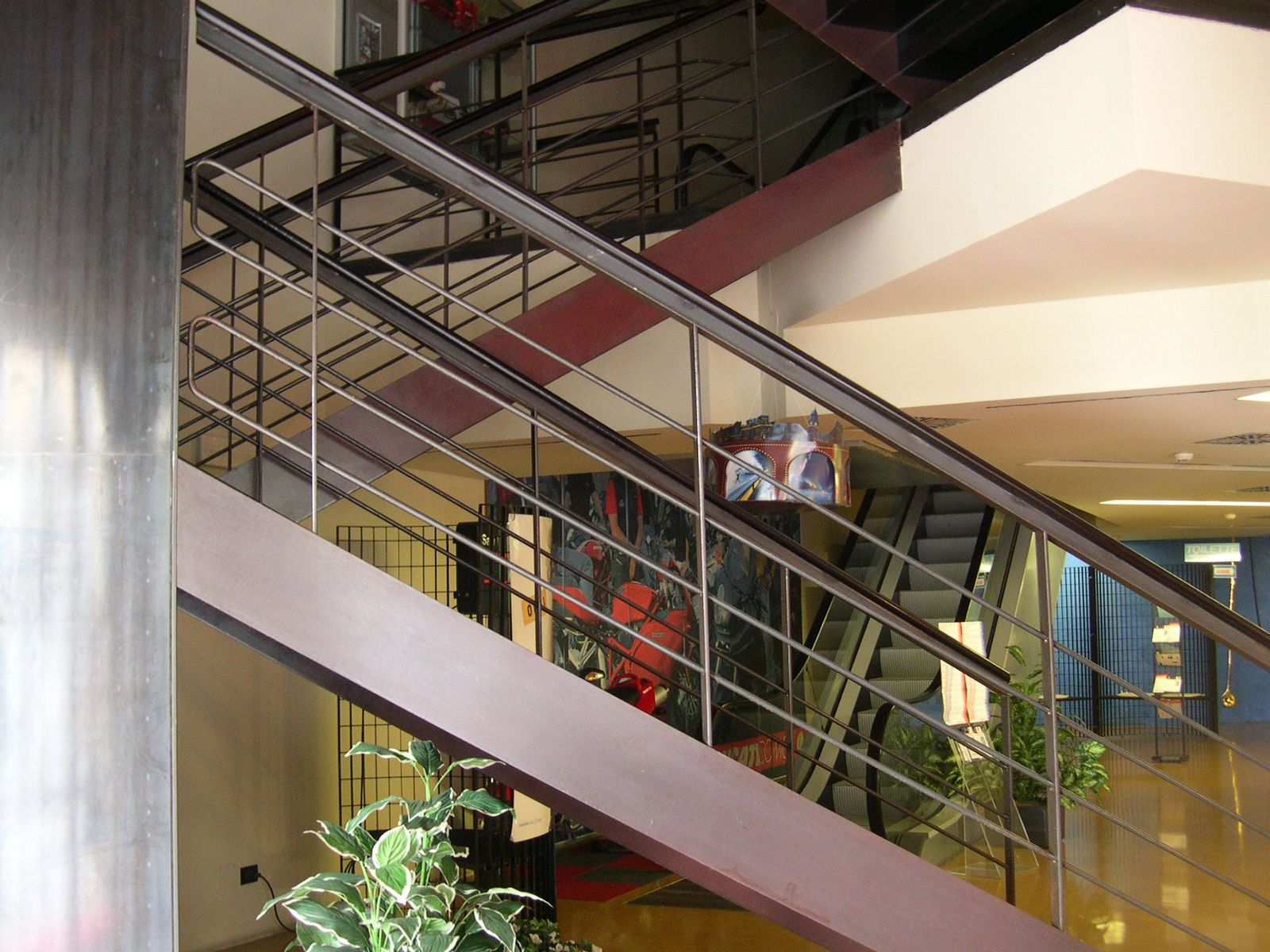 Scala in acciaio con parapetto a correnti in un atrio vetrato