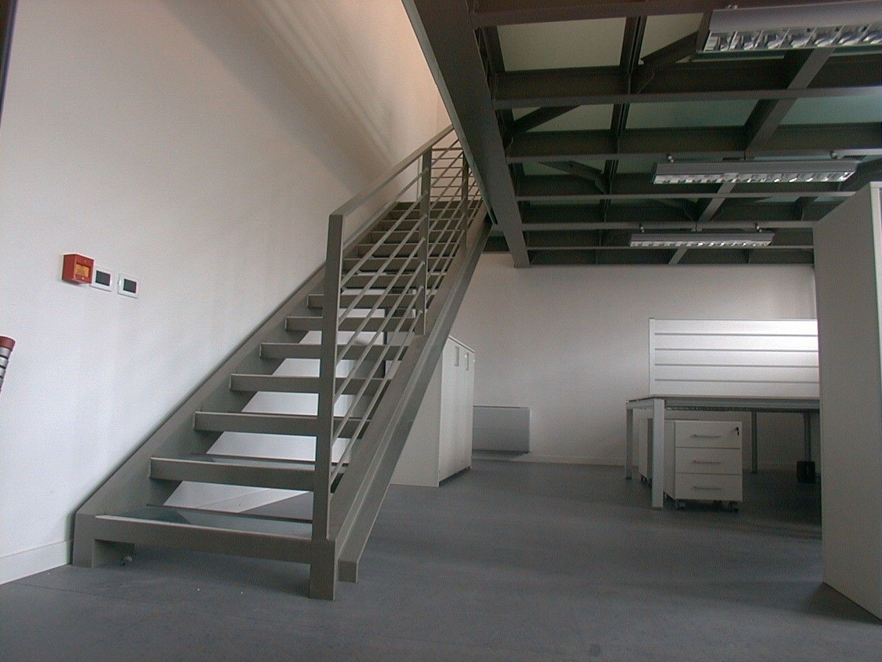 Scala in acciaio con parapetto e soppalco in un ufficio
